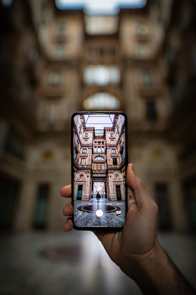 shallow focus photography unknown person holding black smartphone